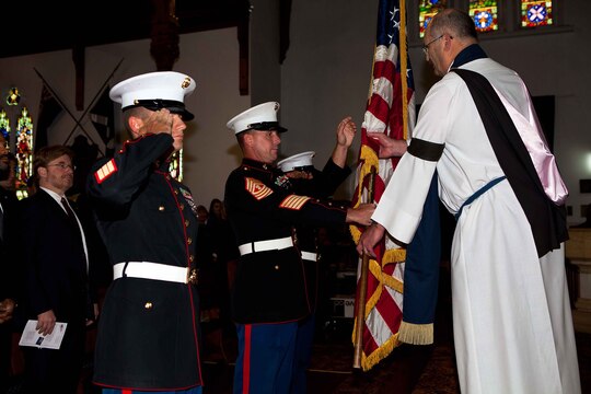 Master Gunnery Sgt. Mark D. Gleason, staff noncommissioned officer-in-charge, U.S. Marine Corps Forces, Pacific Band, presents the American flag to Kim Francis, pastor of the St. Andrew’s on Liardet Church, during the 9/11 Memorial Service here Sept 11. The U.S. Ambassador to New Zealand, David Huebner, and the American rugby team, the Eagles, were present at the 10th anniversary memorial service.