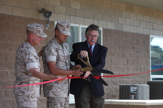 Col. James W. Clark (left), commanding officer of CLR-17, Lance Cpl. Jose G. Pineda (middle), maintenance management clerk, Headquarters and Support Company, Combat Logistics Regiment 17, 1st Marine Logistics Group,, and Pete LeClair (right), operations manager, Hensel and Phelps Construction Company, cut the ribbon during the ceremony of four new bachelor enlisted quarters in 14 Area, Camp Pendleton, Calif., Sept. 12.
