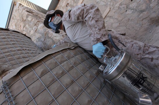 Petty Officer 2nd Class Daniel Walker, a preventative medicine technician with II Marine Headquarters Group, Regional Command Southwest, sprays a broad spectrum insecticide into an Oriental hornet nest at Forward Operating Base Zeebrugge, Afghanistan, Sept. 24. Walker, along with another sailor, visited the base for a series of pest treatments. (U.S. Marine Corps photo by Sgt. Justin J. Shemanski)