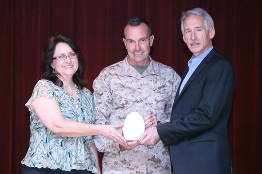 Steve (right) and Judy Wagner (left), 2nd Battalion, 5th Marines Family Readiness Program assistants and advisors, accept an award from Brig. Gen. Vincent Coglianese (center), commanding general of Marine Corps Installations West, for Team Volunteer of the Year during a recognition ceremony at the Pacific Views Event Center at Camp Pendleton, Calif., April 19.  The Wagner team served more than 1000 hours volunteering for holiday parties, baby showers, pre-deployment briefs, cleaning barracks rooms and improving the quality of life of Marines, sailors and family members of the unit. Their off-base service included Operation Help a Hero.