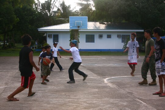 Filipino children from the Bahay Ni Nanay Orphanage play basketball with U.S. Marines and sailors at Antonio Bautista Air Base in Puerto Princesa, Palawan, Republic of the Philippines, April 21, 2012. The children and service members spent several hours together getting to know one another and playing games. The service members are currently here for the duration of Balikatan 2012 and are part of Task Force Palawan. BK12 is a bilateral, joint exercise conducted annually between the U.S. and the Republic of the Philippines. This year marks the 28th iteration of the nations' exercise.