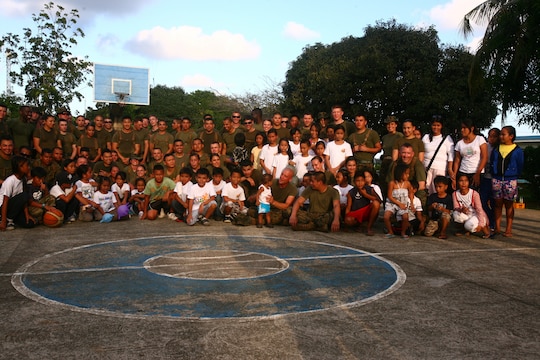 Filipino children and staff from the Bahay Ni Nanay Orphanage pose with U.S. Marines and sailors for a group photo on Antonio Bautista Air Base in Puerto Princesa, Palawan, Republic of the Philippines, April 21, 2012. The children and service members spent several hours together getting to know one another by playing games. The service members are currently here for the duration of Balikatan 2012 and are a part of Task Force Palawan. BK12 is a bilateral, joint exercise conducted annually between the U.S. and the Republic of the Philippines. This year marks the 28th iteration of the nations' exercise.