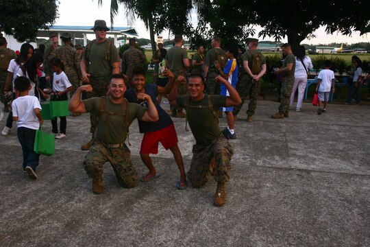 A Filipino child from the Bahay Ni Nanay Orphanage flexes his muscles with U.S. Marines on Antonio Bautista Air Base in Puerto Princesa, Palawan, Republic of the Philippines, April 21, 2012. The children, Marines and sailors spent several hours together getting to know one another and playing games. The service members are currently here for the duration of Balikatan 2012 and are a part of Task Force Palawan. BK12 is a bilateral, joint exercise conducted annually between the U.S. and the Republic of the Philippines. This year marks the 28th iteration of the nations' exercise.