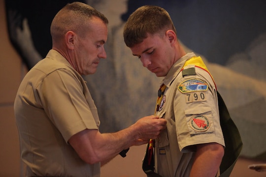 Brig. Gen. Vincent A. Coglianese, commanding general of Marine Corps Installation West - Marine Corps Base Camp Pendleton pins the 'Honor Medal with crossed palms' on Connor F. Stotts, an Eagle Scout with Camp Pendleton's Boy Scout Troop 790. Stotts was presented the coveted Boy Scouts of America 'Honor Medal with crossed palms'. Stotts was awarded the medal in recognition for single handedly saving the lives of three swimmers, July 31, 2011.