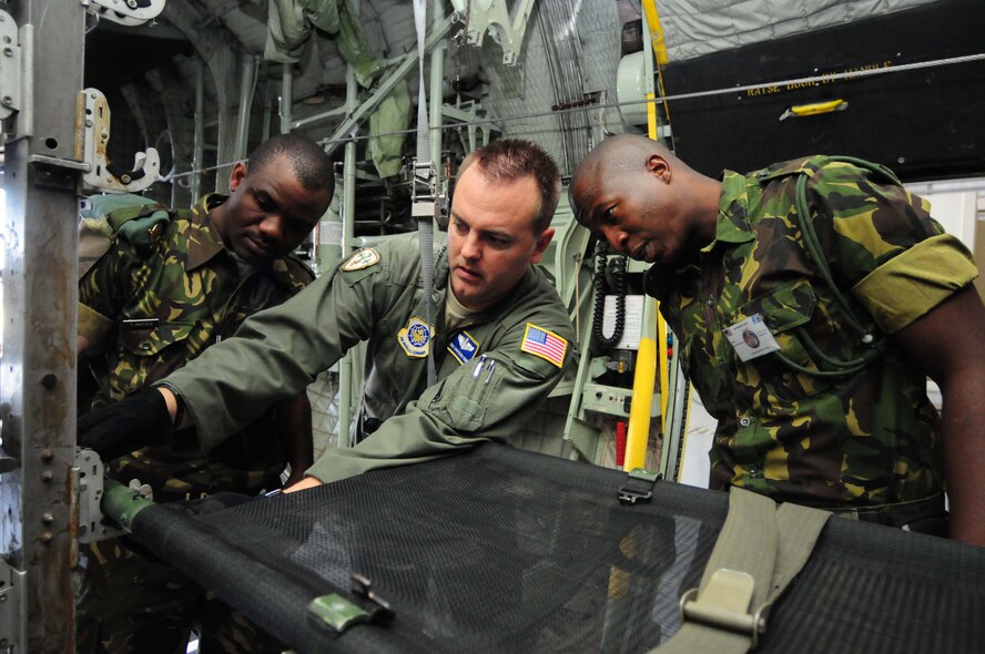 U.S. Air National Guard Master Sgt. Chris Choate (center), 156th Aeromedical Evacuation Squadron, shows members of the Botswana Defense Force how to properly secure a litter on a BDF C-130 Hercules as part of MEDLITE 12 at Thebephatswa Air Base, Botswana, Aug. 11, 2012. MEDLITE is an annual exercise bringing together U.S. forces personnel with counterparts from militaries throughout Africa. The goal of the exercise is to enhance capabilities and work together by introducing the U.S. Aeromedical Evacuation system of patient movement to the BDF military personnel. (U.S. Air Force photo/Senior Airman Lausanne Morgan)