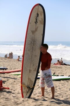 Wounded Warrior, Sgt. Michael Spivey, a combat engineer with 1st Combat Engineer Battalion, stands with his surfboard, waiting for another participant, before attacking the Pacific Ocean waves during a three-day surf camp at Camp Pendleton's San Onofre Beach, Aug. 12. Operation Amped held the sport therapy camp to provide surfing lessons to rehabilitating injured service members and their families.::r::::n::