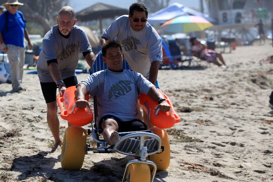 Chris Small, a volunteer with Operation Amped and a left leg amputee, test out at recently donated beach wheelchair during a three-day surf camp at Camp Pendleton's San Onofre Beach, Aug. 12. Operation Amped held the sport therapy camp to provide surfing lessons to rehabilitating injured service members and their families.