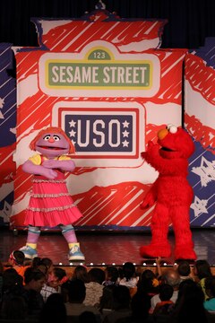 Katie, the newest character on the Sesame Street/USO show, and Elmo dance to the last song of the Sesame Street/USO Experience for Military Families at the Bulldog Box Office, Marine Corps Base Camp Pendleton, Aug. 14. During the show, Katies Sesame friends help her over come her fear of change when she learns that her family will be moving to a different military base.