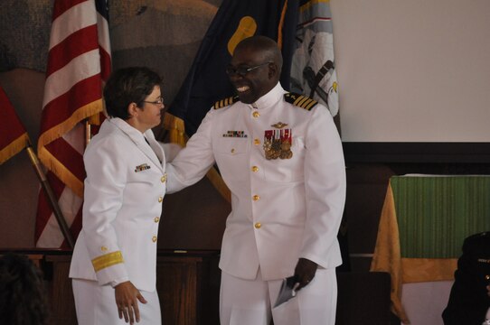 Navy Capt. Ollis J. Mozon, Jr., the Marine Corps Installations-West and Marine Corps Base Camp Pendleton chaplain, embraces fellow chaplain Rear Adm. Margaret Kibben, Chaplain of the Marine Corps and Deputy Chief of Navy Chaplains, during his retirement ceremony at the Blinder Memorial Chapel here, Aug. 17. Kibben spoke on behalf of Mozon, whom she worked with at the U.S. Naval Academy more than a decade ago.