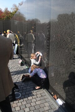 A young girl stencils the name of a fallen warrior from the Vietnam Memorial in Washington D.C. Nov. 10. Visitors can stencil any name on the wall as a souvenir. 