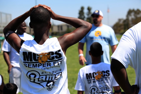 Military family youth participants receive coaching before being introduced to blocking drills. Young, aspiring athletes, ages 6-17, received coaching from former professional athletes during the 2nd Annual Eric Dickerson Foundation Youth Football and Cheer Camp at Camp Pendleton's Paige Fieldhouse, July 19 and 20.