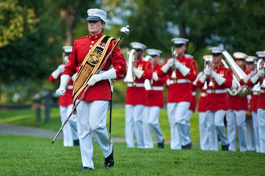 Sgt. Coutrney R. Lawrence, Houston-native who served the role of drum major for the Marine Drum & Bugle Corps, leads in front of the D&B as it marches onto the field at the start of a Tuesday Sunset Parade at the Marine Corps War Memorial in Arlington, Va., July 24. Sgt. Maj. Micheal P. Barrett, sergeant major of the Marine Corps, served as the hosting official for this parade, which featured noncommissioned officers in positions traditionally held by officers and staff noncommissioned officers. The drum major, a position traditionally held by a gunnery sergeant or higher, is the senior-billeted Marine in the D&B and leads the musical unit in its ceremonies by both directing the Marines as they march and conducting them as they play.