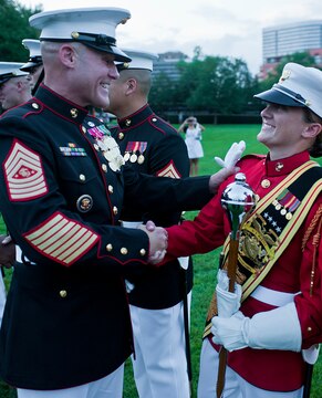 Sgt. Maj. Micheal P. Barrett, sergeant major of the Marine Corps, congratulates Sgt. Coutrney R. Lawrence, Houston-native who served the role of drum major for the Marine Drum & Bugle Corps, on her performance after a Tuesday Sunset Parade at the Marine Corps War Memorial in Arlington, Va., July 24. Barrett served as the hosting official for this parade, which featured noncommissioned officers in positions traditionally held by officers and staff noncommissioned officers. The drum major, a position traditionally held by a gunnery sergeant or higher, is the senior-billeted Marine in the D&B and leads the musical unit in its ceremonies by both directing the Marines as they march and conducting them as they play.