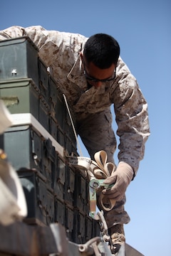 Lance Cpl. Jason Gonzalez, a motor transport operator with General Support Motor Transport, 1st Maintenance Battalion (-) (Reinforced), 1st Marine Logistics Group (Forward), tightens down a load of ammunition during a mass movement at Camp Leatherneck, Afghanistan, June 18. Marines with GSMT contributed to the movement of more than 6.6 million rounds.