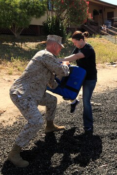 Shannon Love executes knee strikes as she runs though the defensive tactics course while under the effects of the Oleoresin Capsicum spray, also known as pepper spray, during the Security Battalion's Jane Wayne Day on Camp Pendleton, June 23. Along with the knee strikes, spouses performed other defensive tactics such as slashes, thrusts and blocks. Love is the spouse of Sgt. Nicholas P. Love from Security Bn.