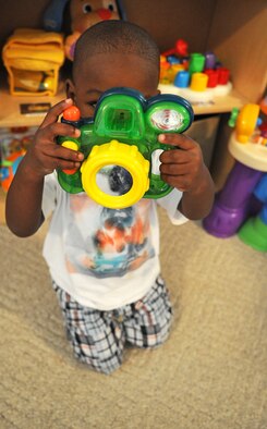 Kilan Johnson, 2, pretends to take a photo while playing at the Phaneuf residence in Goldsboro, N.C., May 7, 2012. Family child care providers offer an array of services to military personnel and DoD civilians to include 24-hour child care. Kilan is the son of Senior Airman Kimberly McAllister, 4th Equipment Maintenance Squadron armament flight, and hails from Goldsboro, N.C. (U.S. Air Force photo/Airman 1st Class Aubrey Robinson/Released)