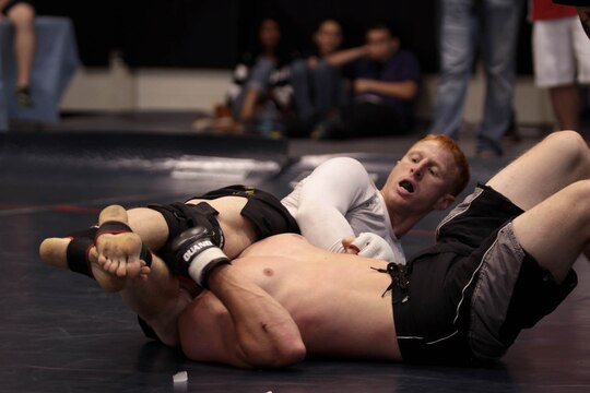 Kyle Stewart, a Marine from the Marine Corps Air Ground Combat Center, finishes the competition with a leg scissor at the 2012 US Armed Services Pankration Championship, held on Camp Horno, May 12. Stewart eventually became the first place winner for the 170 pound weight class.