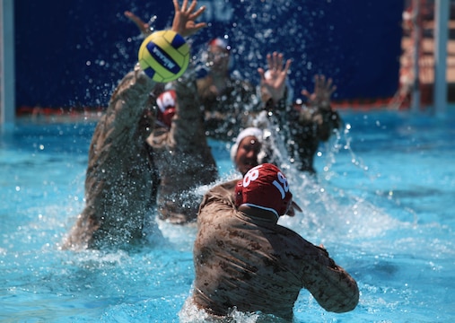 A Camp Pendleton Marine has his shot blocked by defenders during a combat water polo game, May 16, at Camp Pendleton’s 13 Area Pool. Combat water polo was modified from the traditional sport of water polo to provide Marines and sailors the increased safety of a shallow playing field while maintaining difficulty by adding combat boots and utilities.