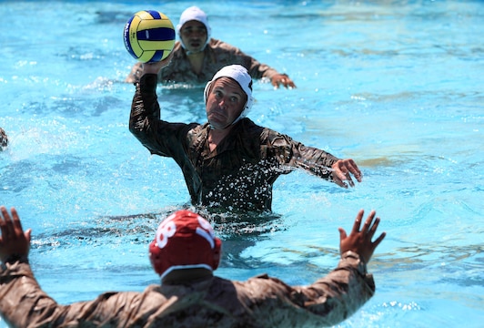 A Camp Pendleton Marine creates space between himself and opponents and prepares to score a goal during a combat water polo game, May 16, at Camp Pendleton’s 13 Area Pool. Combat water polo was modified from the traditional sport of water polo to provide Marines and sailors the increased safety of a shallow playing field while maintaining difficulty by adding combat boots and utilities.
