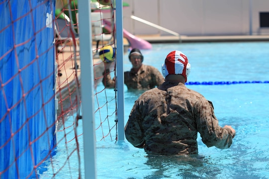 A goalkeeper defends his team’s goal during a combat water polo game, May 16, at Camp Pendleton’s 13 Area Pool. Combat water polo was modified from the traditional sport of water polo to provide Marines and sailors the increased safety of a shallow playing field while maintaining difficulty by adding combat boots and utilities.