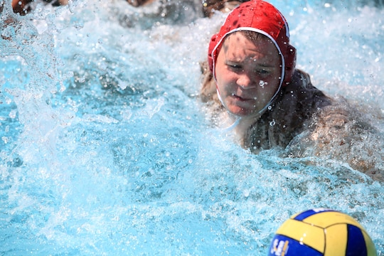 A Camp Pendleton Marine quickly swims to a ball avoiding a turnover and maintaining offensive possession during a combat water polo game, May 16, at Camp Pendleton’s 13 Area Pool. Combat water polo was modified from the traditional sport of water polo to provide Marines and sailors the increased safety of a shallow playing field while maintaining difficulty by adding combat boots and utilities.