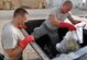 U.S. Air Force Staff Sgt. Jeff Kisamore (left) and Airman 1st Class Adam Cassada, 386th Expeditionary Civil Engineer Squadron Force Protection Flight Garbage Disposal Escort Team, rip open bags in a garbage dumpster during sweeps at an undisclosed location, Southwest Asia, May 16, 2012. The GDE Airmen go into the dumpsters twice, sometimes three times a day looking for things that can pose safety and security risks for U.S. and host nation personnel.  Kisamore is a Pelham, Ala., native deployed from the 18th Dental Squadron, Kadena Air Base, Japan.  Cassada is a Charlotte, N.C., native deployed from the 354th Operation Support Squadron, Eielson Air Force Base, Alaska. (U.S. Air Force photo/Tech. Sgt. Stacy Fowler)