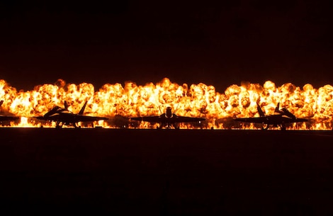 Flames explode behind the Navy Blue Angels' F/A-18 Hornets during the night portion of the 2012 Marine Corps Air Station Miramar Air Show, Oct. 13. The wall of fire is the last event of the night air show.