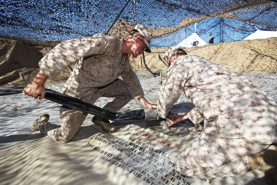Marines with Bulk Fuel Company, 7th Engineer Support Battalion, 1st Marine Logistics Group, 
connect a hose to a fuel storage container during a field training exercise at Camp Pendleton, Calif., Oct. 15. The construction and maintenance of the fuel farm gave junior Marines an opportunity to develop their skills and support the 7th ESB field exercise.