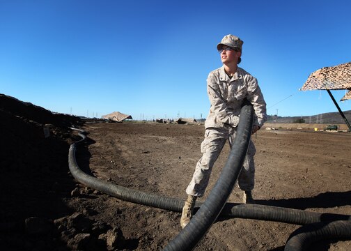 19-year-old Lance Cpl. Elizabeth Potts, from Pittsburgh, a bulk fuel specialist with Bulk Fuel Company, 7th Engineer Support Battalion, 1st Marine Logistics Group, drags a fuel hose during a field training exercise at Camp Pendleton, Calif., Oct. 15. Bulk fuel specialists constructed a 320,000-gallon storage facility to support the field exercise.