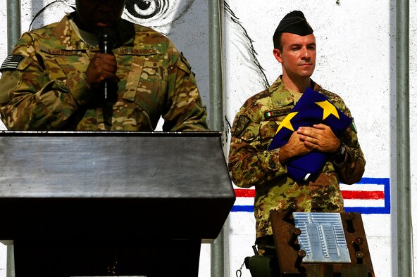 U.S. Air Force Master Sgt. Tammala Lawson, foreground, reads a narrative while Italian Air Force Maj. Max Pinardi stands in front of piece of the World Trade Center during the September 11 Memorial Ceremony, Sept. 11, 2012 at Kabul Afghanistan, International Airport Afghanistan. The ceremony was to honor those who lost their lives in the September 11 terrorist attacks and the men and women of the Department of Defense fighting the war on terrorism. (U.S. Air Force photo/Tech. Sgt. Quinton Russ/RELEASED)