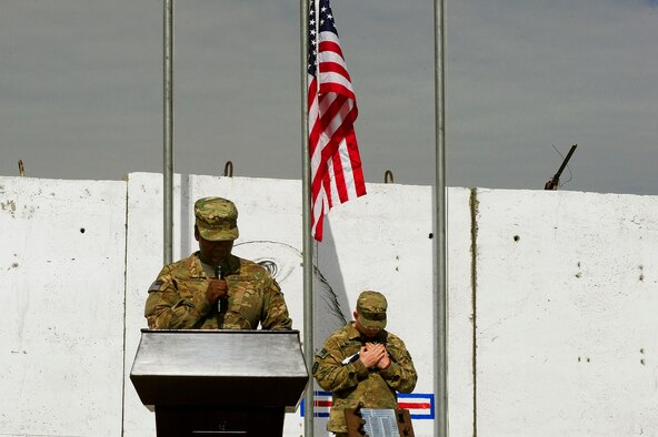 U.S. Air Force Master Sgt. Tammala Lawson, foreground, reads a narrative while U.S. Army Cpl. Nicholas Maag stands in front of piece of the World Trade Center during the September 11 Memorial Ceremony, Sept. 11, 2012 at Kabul Afghanistan, International Airport Afghanistan. The ceremony was to honor those who lost their lives in the September 11 terrorist attacks and the men and women of the Department of Defense fighting the war on terrorism. (U.S. Air Force photo/Tech. Sgt. Quinton Russ/RELEASED)