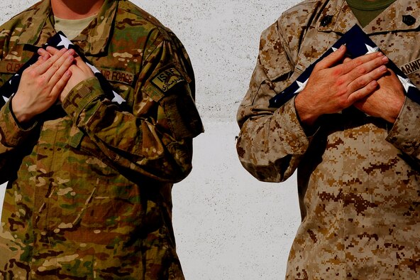 U.S. Marine Corps. Gunnery Sgt. James Jacobs and U.S. Air Force Airman 1st Class Carl Clements holds the nations flag during the September 11 Memorial Ceremony, Sept. 11, 2012 at Kabul Afghanistan, International Airport Afghanistan. The ceremony was to honor those who lost their lives in the September 11 terrorist attacks and the men and women of the Department of Defense fighting the war on terrorism. (U.S. Air Force photo/Tech. Sgt. Quinton Russ/RELEASED)