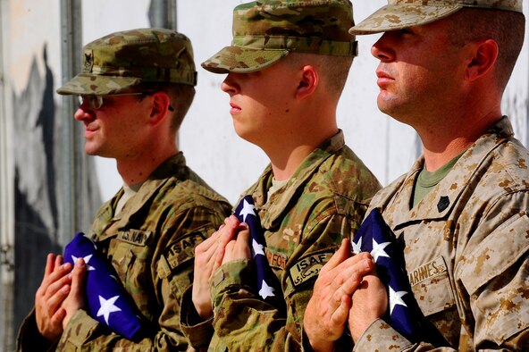 U.S. Marine Corps. Gunnery Sgt. James Jacobs, foreground, U.S. Air Force Airman 1st Class Carl Clements, middle, and U.S. Navy Petty Officer 2nd Class Bryan Addleman carries the nations flag during the September 11 Memorial Ceremony, Sept. 11, 2012 at Kabul Afghanistan, International Airport Afghanistan. The ceremony was to honor those who lost their lives in the September 11 terrorist attacks and the men and women of the Department of Defense fighting the war on terrorism. (U.S. Air Force photo/Tech. Sgt. Quinton Russ/RELEASED)