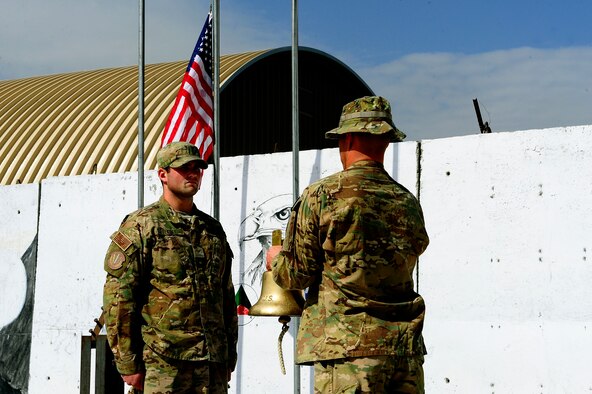 U.S. Air Force Senior Amn Robert Tisdale, left, stands in silence after ringing the bell during the September 11 Memorial Ceremony  Sept. 11, 2012 at Kabul Afghanistan, International Airport Afghanistan. The ceremony was to honor those who lost their lives in the September 11 terrorist attacks and the men and women of the Department of Defense fighting the war on terrorism. (U.S. Air Force photo/Tech. Sgt. Quinton Russ/RELEASED)