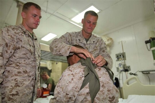 Marines from the 15th Marine Expeditionary Unit practice applying arm carriages during a Combat Life-saving Skills course aboard the USS Rushmore, Aug. 23. The four-day course teaches Marines how to give basic level care in order to prevent the loss of casualties on the battlefield.