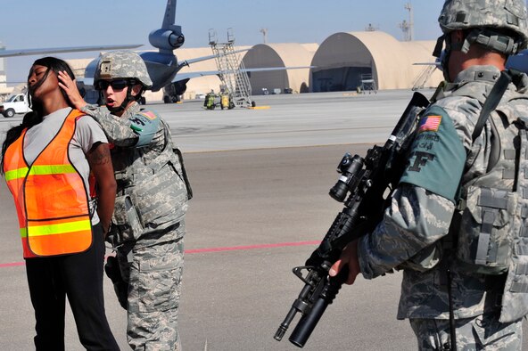 U.S. Air Force Senior Airman Amber Ricketson, 380th Expeditionary Security Forces Squadron quick response force, apprehends an intruder played by Staff Sgt. Tiffany Cooke, 380 SFS training member, while Staff Sgt. Daniel Kaltenegger, 380 SFS patrolman, provides cover during a base defense exercise at an undisclosed location in Southwest Asia Mar. 29, 2013. The exercise objective was to test the security forces reaction-time in the event that intruders threatened Air Force assets. Ricketson is deployed from Joint Base Lewis-McCord, Wash., Cooke is deployed from Wright-Patterson AFB, Ohio and Kaltenegger is deployed from Pennsylvania Air National Guard. (U.S. Air Force photo by Tech. Sgt. Christina M. Styer) 

