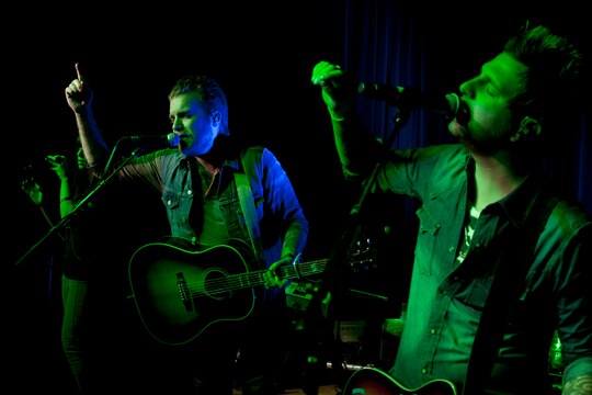 Gloriana performs on stage at the Pacific Views event Center here during the premiere of Stan Lee's POW!er Concerts April 5. The band is comprised of Rachel Reinert, left, Tom Gossin, center, and Mike Gossin, right. POW!er Entertainment's mission is to honor and pay tribute to the courageous everyday superheroes of the Armed Forces by bringing live entertainment with a superhero theme to the home front.