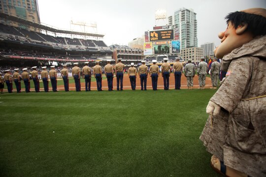 Marines with 1st Marine Logistics Group and other military units throughout California stand at attention as the San Diego Padres mascot looks on during a Military Appreciation Day event at Petco Park, April 14, 2013. The Major League Baseball team hosts these events regularly to show their appreciation for the large military influence present in California.