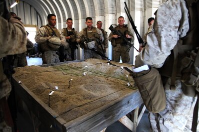 Marines with 1st Maintenance Battalion, 1st Marine Logistics Group, study a terrain model prior to a patrol during the Basic Combat Skills Course aboard Camp Pendleton, Calif., April 18, 2013. Approximately 40 Marines participated in the three-week course designed to refresh Marines in the basics of Marine Corps combat skills to keep them ready for battle.