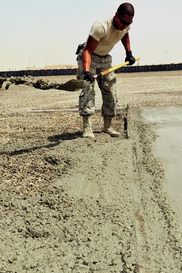 U.S. Air Force Staff Sgt. Duncan Bolt, 380th Air Expeditionary Wing structures journeyman, removes excess concrete along freshly poured pads at an undisclosed location in Southwest Asia April 16, 2013. There are 20 "Dirt Boyz" responsible for constructing projects that will transition the 380th Air Expeditionary Wing from expeditionary to enduring. Bolt is deployed from Hurlburt Field, Fla. (U.S. Air Force photo by Tech. Sgt. Christina M. Styer)