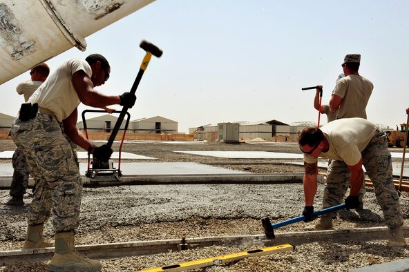 U.S. Air Force Staff Sgts. Duncan Bolt and Garrett Hanson, 380th Air Expeditionary Wing structures journeymen, pound stakes into a frame used for laying concrete pads at an undisclosed location in Southwest Asia April 16, 2013. The "Dirt Boyz" have dug trenches, poured concrete, set up t-walls, and concrete pads throughout the installation to aid in the transition from expeditionary to enduring. Bolt is deployed from Hurlburt Field, Fla., and Hanson is deployed from Mountain Home Air Force Base, Idaho. (U.S. Air Force photo by Tech. Sgt. Christina M. Styer)
