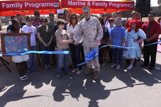 Brig. Gen. Vincent A. Coglianese and his wife, Mary, snip a ribbon with Nolan Gloud to signify the commencement of the 18th annual Kids First Fair hosted by Marine and Family Programs at the Paige Field House here April 27. Coglianese is the base commanding general and regional authority for five Marine Corps installations in the southwestern United States. Gloud is an actor who plays the role of Luke Dunphy on the sitcom Modern Family. 