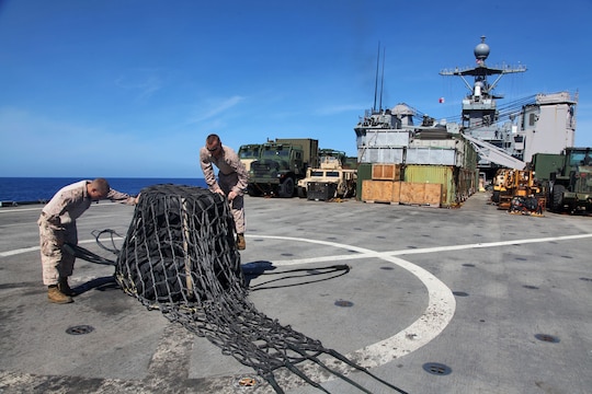 130427-M-VZ265-009 USS RUSHMORE (April 27, 2013) Marines assigned to Transportation Support  Detachment, Combat Logistics Battalion 15, 15th Marine Expeditionary Unit, secure a cargo net over three tires before a helicopter support team conducts an aerial lift aboard USS Rushmore, April 27. The team of four conducted a total of seven aerial lifts to refresh their skills. To assist them, the pilot and crew of a CH-46E Sea Knight assigned to Marine Medium Helicopter Squadron 364 (Rein.), 15th MEU, participated in the exercise to bolster both the Marines on the flight deck and their own training. The 15th MEU is comprised of approximately 2,400 Marines and sailors and is deployed as part of the Peleliu Amphibious Ready Group. Together, they provide a forward-deployed, flexible sea-based Marine Air Ground Task Force capable of conducting a wide variety of operations ranging from humanitarian aid to combat. (U.S. Marine Corps photo by Cpl. Timothy Childers / Released)
