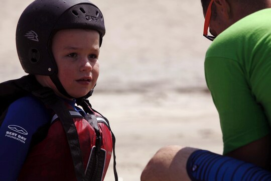 Hayden, 7, plays in the sand with a volunteer from Orange County Best Day Foundation as he waits for his turn to ride in a kayak at the Exceptional Family Member Program's Best Day Beach Event at Del Mar Beach here Aug. 3. Exceptional Family Member Program participants and volunteers with the Orange County Best Day Foundation spent the day surfing, body boarding and Kayaking in an effort to build self-esteem and confidence in children
