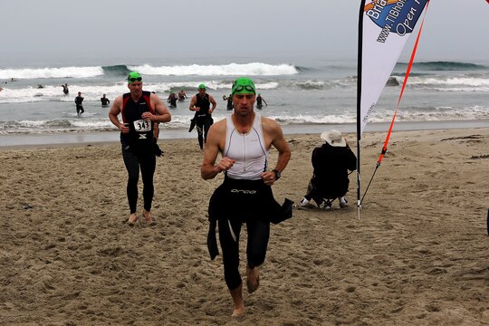 Racers run back onto the beach after the 500 meter swim portion of a triathlon during the Hardcore Race Series’ Semper Tri/Devil Dog Duathlon held at Assualt Craft Unit-5 here August 3. The Semper Tri/Devil Dog Duathlon is the first event where the race series has combined the triathlon and duathlon. Racers were also required to cycle 30 kilometers, and run 5 kilometers to complete the trial.