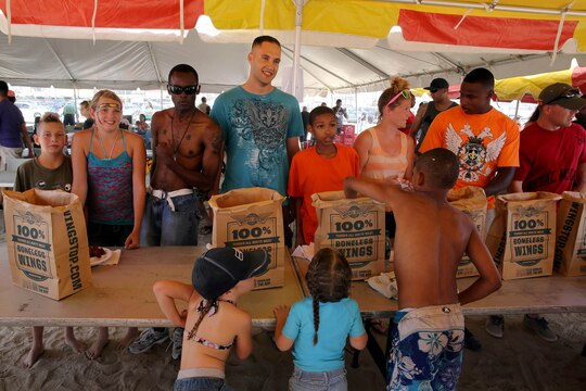 Participants in the hot wing-eating contest pose for a picture before beginning the competition during the Headquarters and Support Battalion Family Day held at Del Mar Beach Resort here August 2. 
