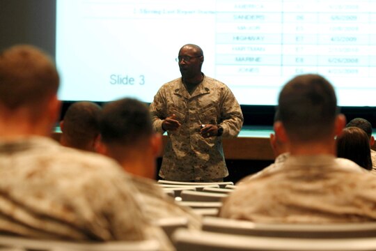Sgt. Maj. Mark A. Byrd explains proper fitness report procedures to more than 45 Marines during the Manpower Management Support Branch Promotion and Performance brief at the base theater here Aug. 7. The brief covered information to assist Reporting Seniors and Reviewing Officers with completing fitness reports, as well as help Marines receiving reports better understand how they are evaluated. Byrd is the sergeant major for the Performance Evaluation Section at Headquarter Marine Corps.