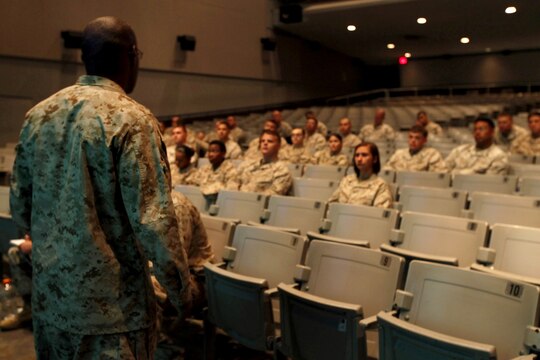 Sgt. Maj. Mark A. Byrd explains the time window for promotion photos during the Manpower Management Support Branch Promotion and Performance brief at the base theater here Aug. 7. The brief covered information to assist Reporting Seniors and Reviewing Officers with completing fitness reports, as well as help Marines receiving reports better understand how they are evaluated. Byrd is the sergeant major for the Performance Evaluation Section at Headquarter Marine Corps.