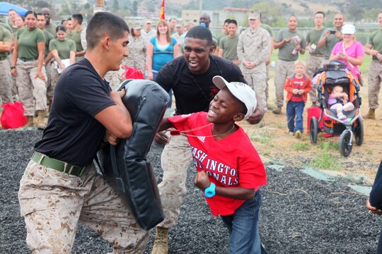 A Marine’s son practices Marine Corps Martial Arts with Marines from 1st Supply Battalion, Combat Logistics Regiment 15, 1st Marine Logistics Group, during the battalion’s Johnny Wayne Day aboard Camp Pendleton, Calif., Aug. 9, 2013. At the family day, the children of Marines and sailors participated in a number of events that simulated what their parents might experience on a day-to-day basis as a member of the military.