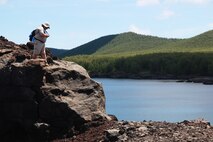 Christopher Stoll, Senior Planner and GIS Specialist with AECOM Naval Facilities Pacific Engineering Command, designates a potential landing zone with a global positioning systems capable camera during a Technical Survey, Pagan, July 30, 2013.  Stoll played a critical role in plotting points and routes of existing roadways, historical markers to enhance and refine existing maps.